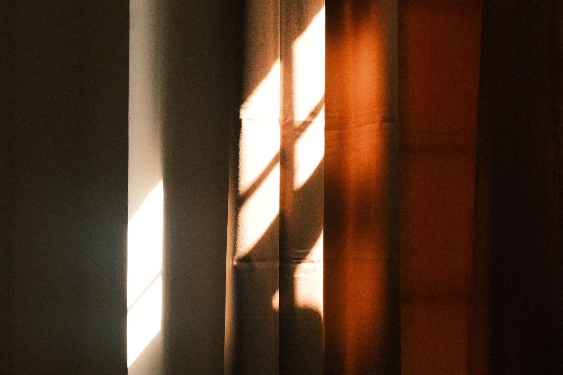 Late afternoon light falling in bands across a textured interior wall.